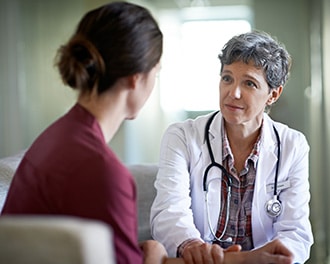 woman visiting with doctor, listening to advice