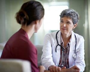 woman visiting with doctor, listening to advice