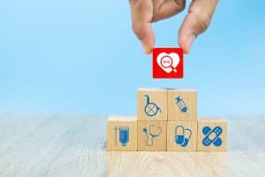 Health care planning with Medical and Health icons on wooden blocks stacked on top of each other