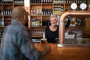 older worker at bar serving beer