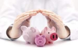 Group of different sized piggy banks covered by hands