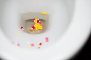 multi-colored pills flushed into the toilet when deceased had controlled substances