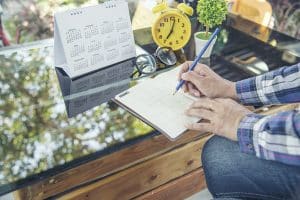 Person using a calendar and note pad for planning