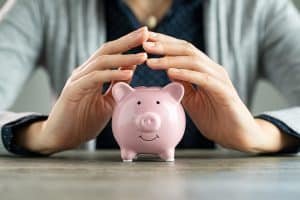 Image of piggy bank being sheltered by hands - symbolizing asset protection