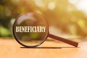 The word BENEFICIARY on magnifier in sunlight.