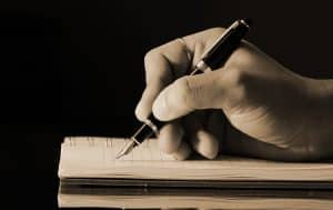 Holding a pen, making a list in a notebook