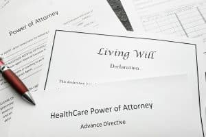 Power of Attorney, Living Will, and Health Care Power of Attorney documents on a desk