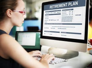 Woman filling out retirement plan forms on computer