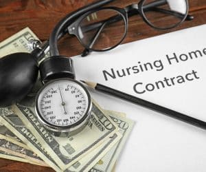Nursing Home Contract on clipboard, a stethescope, glasses, and cash