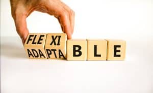 Words Flexible and Adaptable on blocks of wood being turned over with someone's hand 