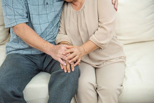 Cropped photo of hands of cute elder senior asian couple holding hands with love on sofa.Old people hug and holding hands. couple concept. loving concept. caring concept.