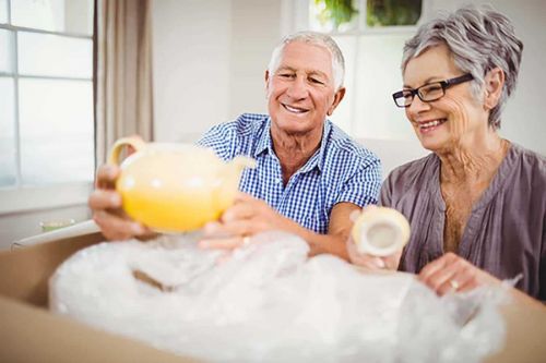 Senior couple unpacking a box of personal property