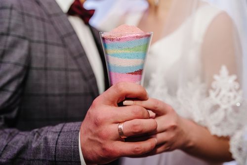 Wedding ceremony, blended family, mixing sands as a new family. Close up view hands of bride and groom doing sand ceremony during wedding, blended family.