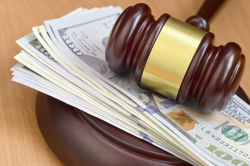 court fees illustrated by a stack of dollar bills under a judge's gavel