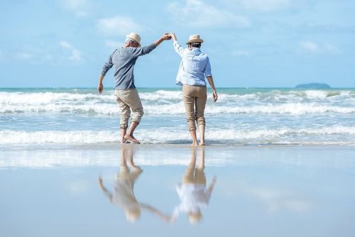 Retirement Travel. Senior couple dancing on the beach happy and relax.