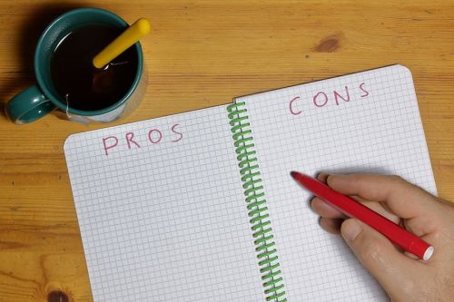 pros cons list in a notebook and man hand with red marker writing considering pros and cons of probate