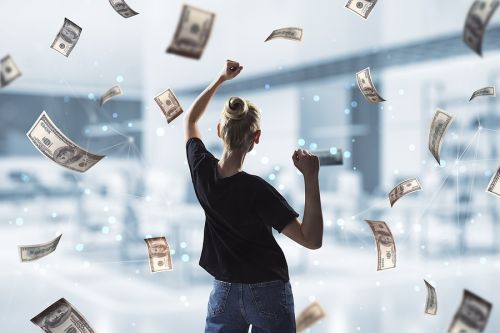 Back view of young successful woman with dollar bill money rain on blurry office interior background. Success, money and lottery winner concept