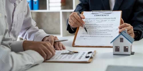 Couple signing a contract at a desk