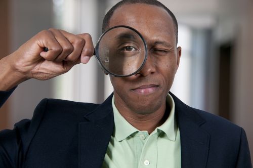 man looking through a magnifying glass