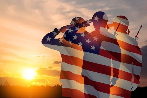 Silhouettes of soldiers in front of a sunset with the US Flag watermarked in the background representing estate planning for veterans