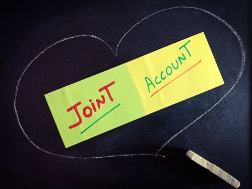 Joint account (JTWROS) text in heart shape presented for active business education concept on paper slip background.