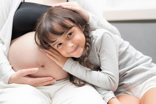 Including unborn children in estate plan image shows child leaning over pregnant mother’s stomach