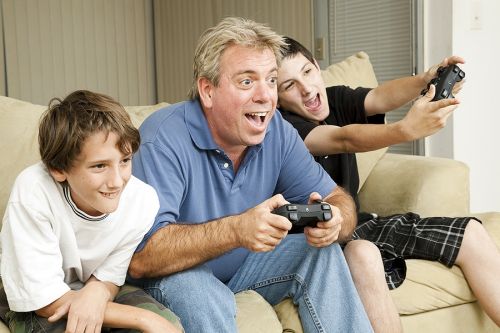 Uncle playing video game with nephews for article about why corporate trustee might be better.