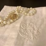 Pearl necklace, class ring, embroidered hankerchief