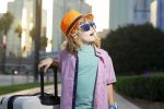 Child with travel suitcase on vacation ready for adventure.